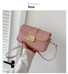 Close-up of pink crocodile pattern crossbody bag with a golden metallic lock closure