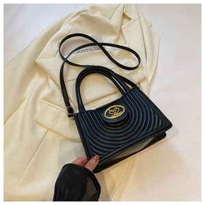 Detail of black PU leather bag with heart metal lock and circular quilted stitching