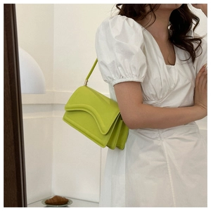 Side view of lime green underarm bag featuring wave flap and accordion-style layers