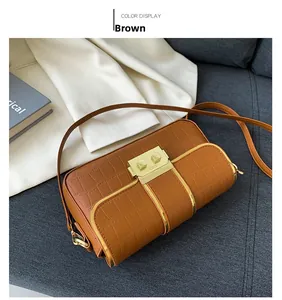 Close-up of brown crocodile texture leather bag with square gold metallic buckle