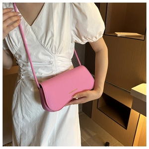 Détail de la texture motif crocodile rose sur un sac à bandoulière chic en cuir PU