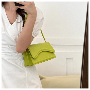 Mirror selfie showing a mint green rectangle shoulder bag with flap and stitch detail