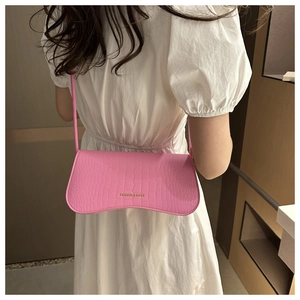 Détail du sac bandoulière rose en similicuir croco avec lettrage doré élégant