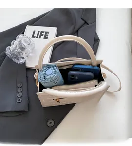 Interior view of the cream crocodile embossed handbag showing capacity for phone and umbrella