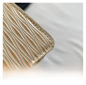 Detailed macro view of yellow wave-patterned epi leather with neat artisanal stitching