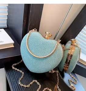 Macro view of blue glitter heart-shaped evening bag with gold metal frame and jewel clasp