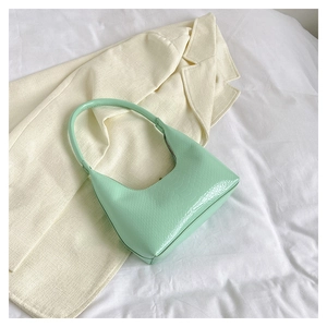 Dettaglio della trama a coccodrillo verde menta su un elegante borsa a mezzaluna