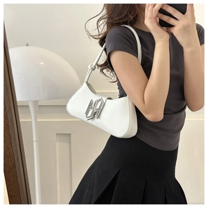 Detail of white crescent leather shoulder bag featuring a silver geometric metal logo