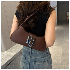 Close-up of brown leather underarm bag featuring a silver metal RP logo and sleek strap