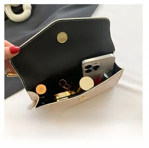 Detail showing beige crossbody bag capacity for smartphone and cosmetics with magnetic clasp