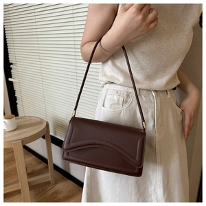 Close-up of a dark brown crocodile pattern shoulder bag with golden metal hardware