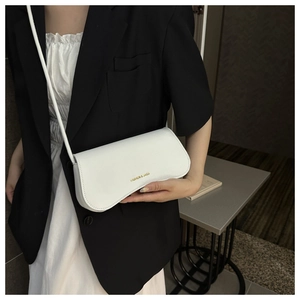 Détail du petit sac blanc carré avec logo doré et fine bandoulière pour femmes