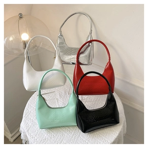 Dettaglio di borse con stampa coccodrillo in argento, bianco, rosso, verde e nero