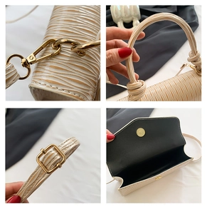 Detailed close-up of golden hardware, textured cream surface and magnetic clasp on handbag