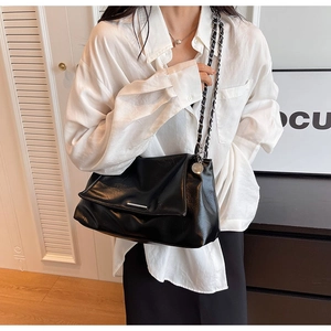 Détail du sac à bandoulière en cuir PU noir avec chaîne argentée et garniture métal
