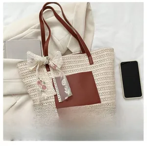Detail of woven straw tote bag with brown leather pocket and elegant floral lace bow