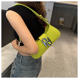 Detail view of neon yellow PU leather underarm bag with silver PD metal lettering charm