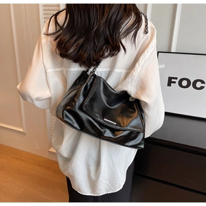Détails du sac à bandoulière noir brillant avec chaîne en métal chic et texture froissée