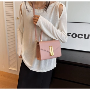 Pink crossbody bag detail showing rectangular gold buckle and premium flap design