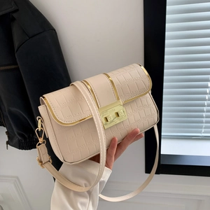 Elegant beige crocodile texture crossbody bag with gold buckle in street style setting