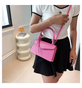 Detail of rose pink pleated PU leather handbag with elegant cylinder handle and texture