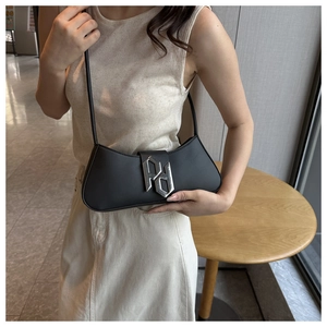 Detail of silver PD buckle on black leather crescent underarm bag worn by model