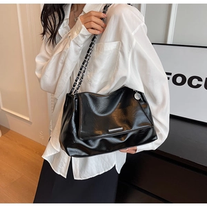 Détail du sac à bandoulière noir plissé vintage avec chaîne argentée et accents métalliques
