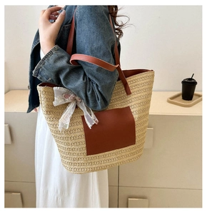 Détail du sac cabas en paille avec anses en cuir marron et nœud floral en dentelle