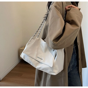 Détail du sac bandoulière en cuir plissé blanc avec chaîne argentée et boucle métal