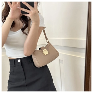 Gros plan d'un sac porté épaule en cuir marron clair avec boucle en métal doré rectangulaire