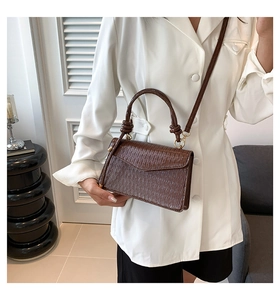 Detail of coffee brown pleated crossbody bag with stylish texture and handle