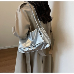 Vue détaillée du sac bandoulière argenté à texture métallisée plissée sur un mannequin
