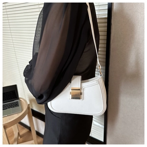 Dettaglio della borsa baguette bianca minimalista in ecopelle con fibbia in metallo dorato