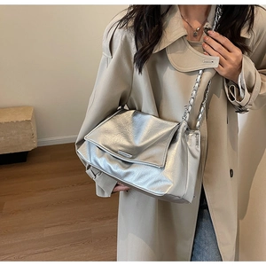 Détail du sac bandoulière argenté métallisé avec texture plissée et chaîne en argent