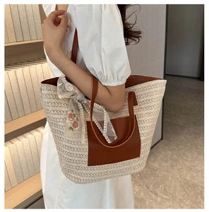 Detail of straw woven tote with leather pocket and decorative floral lace scarf