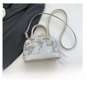 Detail view of grey shell bag with white mountain embroidery and size reference