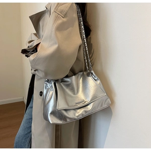 Détail du sac à bandoulière argenté métallisé avec texture plissée et chaîne argentée