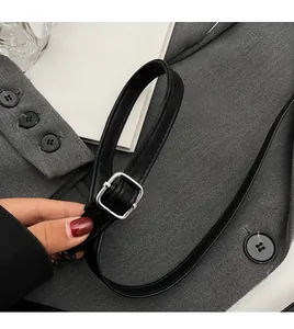 Detail of adjustable black leather shoulder strap with a silver square metal buckle