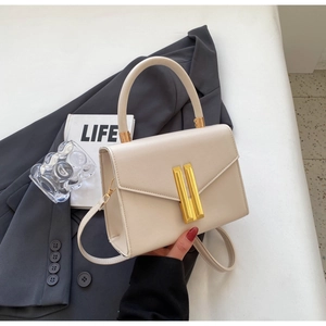 Detail of cream white leather square bag with gold metal buckle and round handle