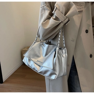 Détail du sac cabas en cuir souple argenté avec chaîne élégante et finition texturée