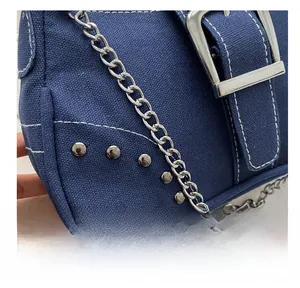 Detail showing blue canvas bag with white contrast stitching and metallic chain strap