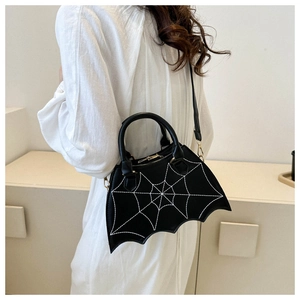 Dettaglio della borsa nera a forma di pipistrello con ricamo a ragnatela e finiture in oro