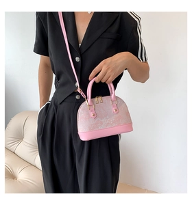 Pink marble pattern shell crossbody bag with golden hardware shown by a model