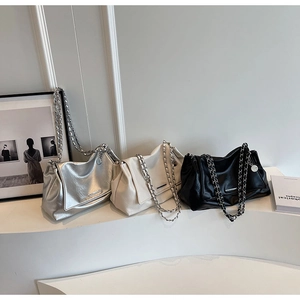 Détail de grands sacs fourre-tout en argent, blanc et noir avec bandoulières à chaîne
