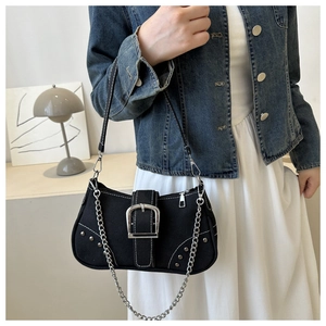 Detail of black canvas underarm bag with large silver buckle and metal chain accent