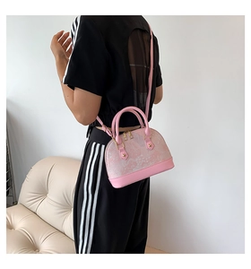 Detailed back view of pink marble shell bag with gold hardware and shoulder strap