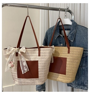 Détail d'un sac cabas en paille tissée avec nœud en dentelle florale et anses en cuir