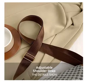 Detail of adjustable dark brown woven strap with gold buckle on retro cylinder bag