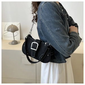 Detail of black canvas shoulder bag with silver buckle and white contrast stitching