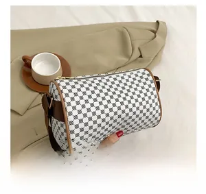 Detail view of retro geometric print cylinder bag with leather trim and wide strap